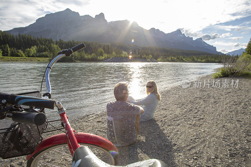 一对夫妇骑着巡洋舰自行车在河岸上放松