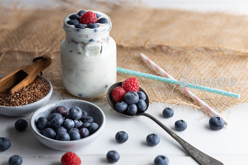 健康超级食品亚麻籽在碗中混合酸奶随时食用。这些种子非常健康，可以与各种不同的菜肴一起食用。