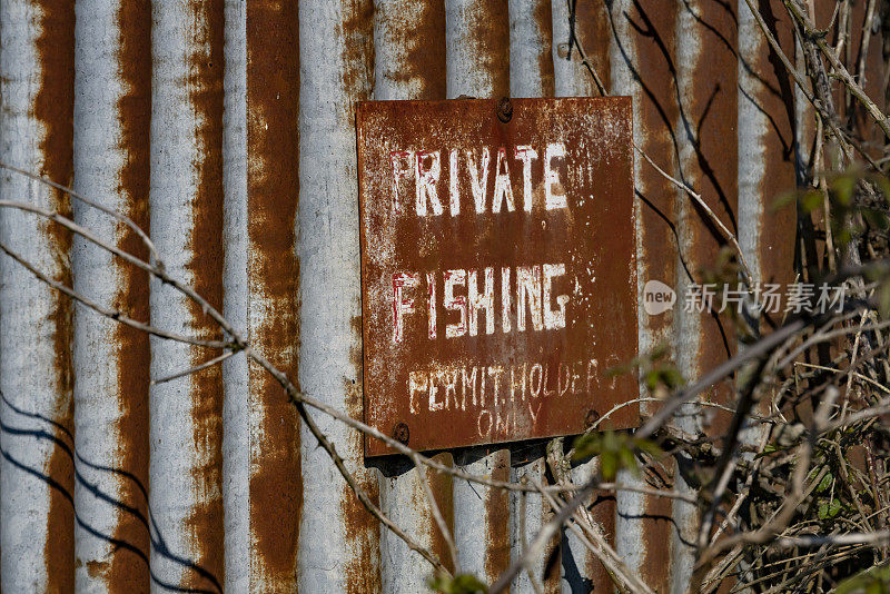 旧瓦楞小屋上的私人钓鱼标志