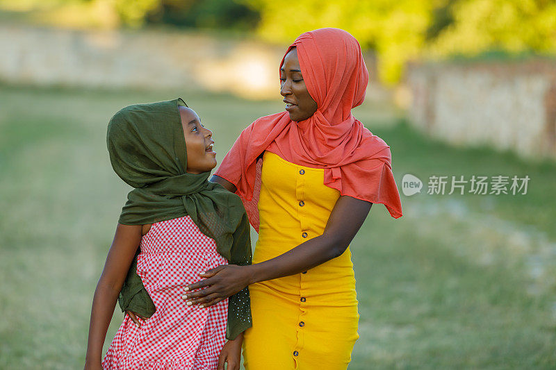 穆斯林母亲和女儿在爱的拥抱肖像。