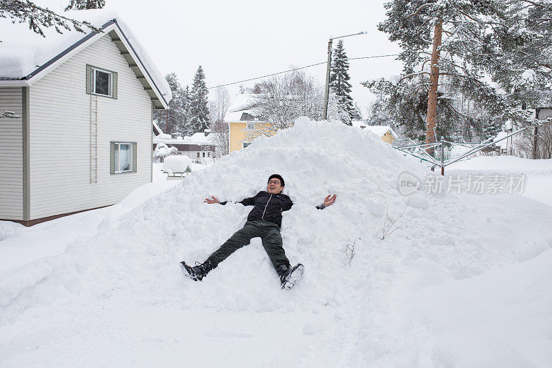 亚洲中国游客到北欧国家愉快地躺在雪地里。
