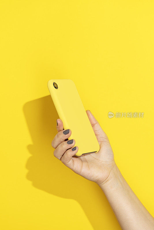 黄色背景的手持手机