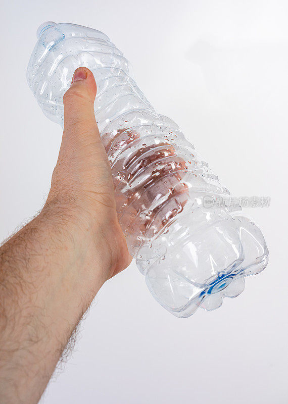 手里拿着一个塑料水瓶