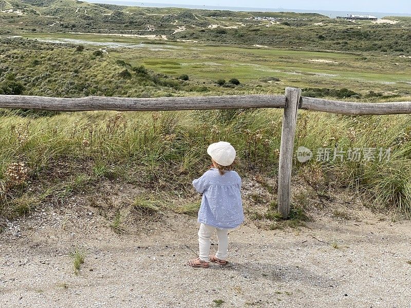小女孩在看沙丘的风景