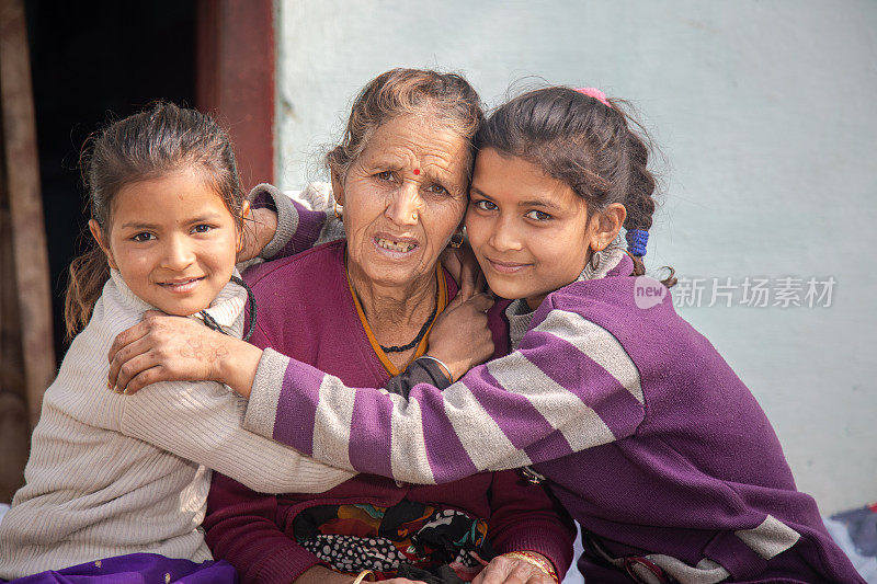 印度母亲和女儿一起坐在村里的传统床上