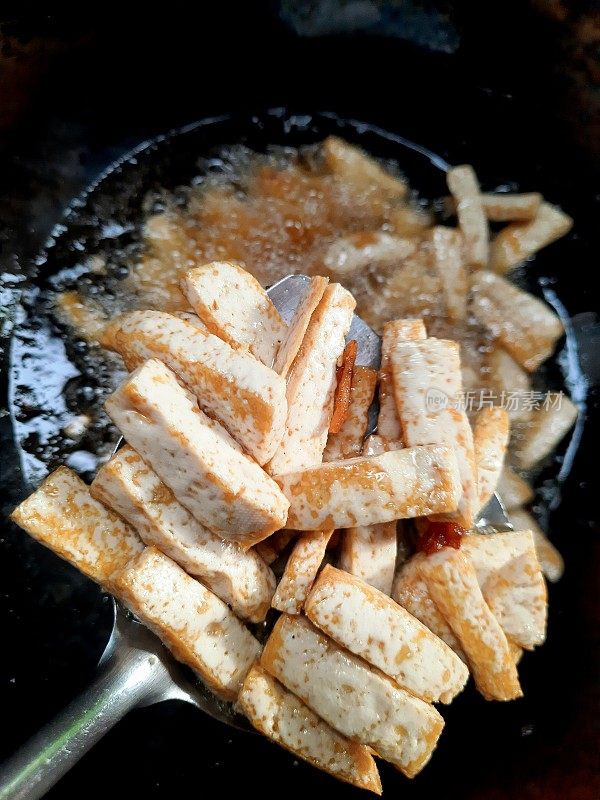 炸芋头在勺上煮食用油背景。