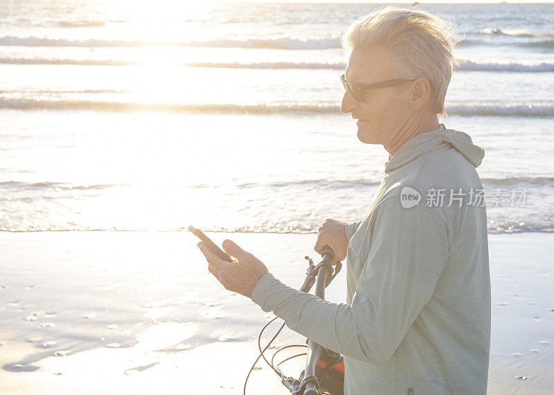 日出时，一名男子骑着自行车沿着空旷的海滩走