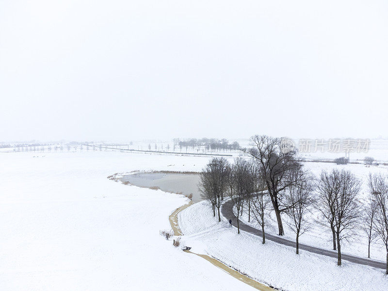 在白雪皑皑的冬天，俯瞰河堤和蜿蜒的道路