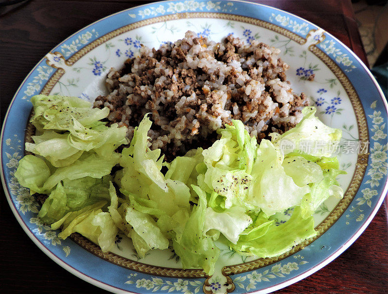 阳光在肉酱、米饭和生菜上发挥作用。