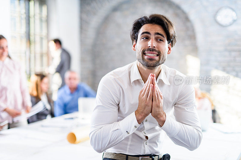 年轻的商人在办公室祈祷。