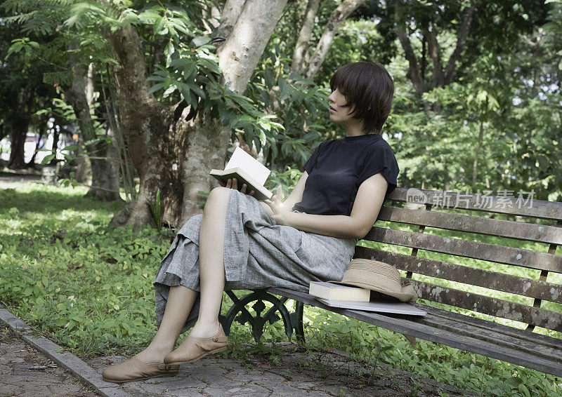 女人坐在老板凳上，看书，爱好度假