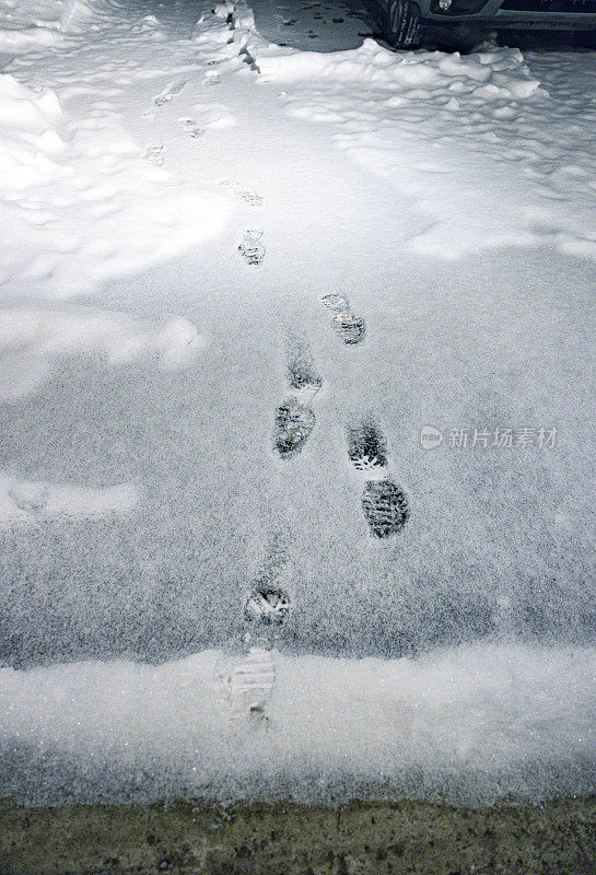 冬雪车道上的黑暗足迹