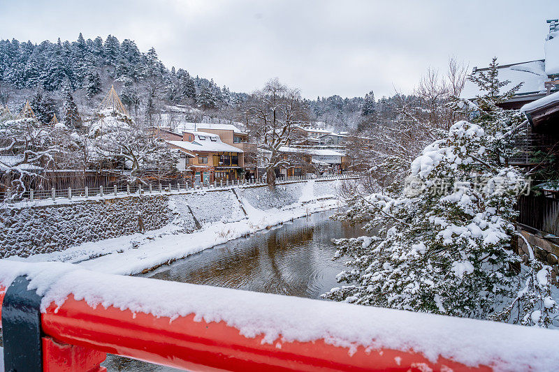 高山村雪与红色木桥和溪水，日本