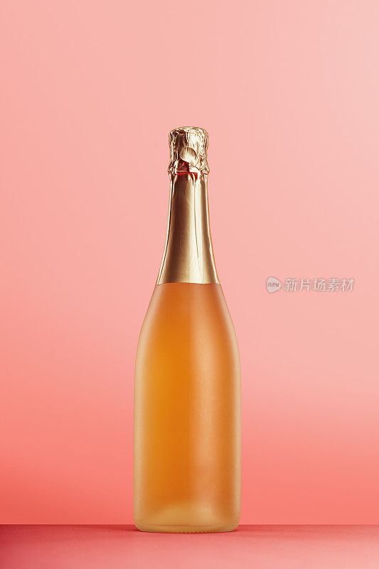 香槟酒瓶在柔和的粉红色背景