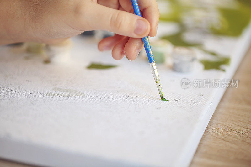 模糊裁剪的照片女性手绘画与笔刷在纸上