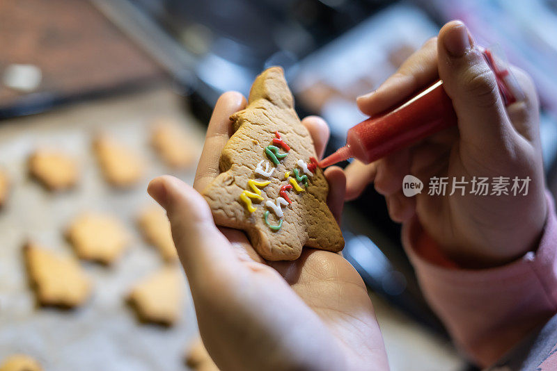 青少年正在厨房制作圣诞饼干，重点是前景水平照片