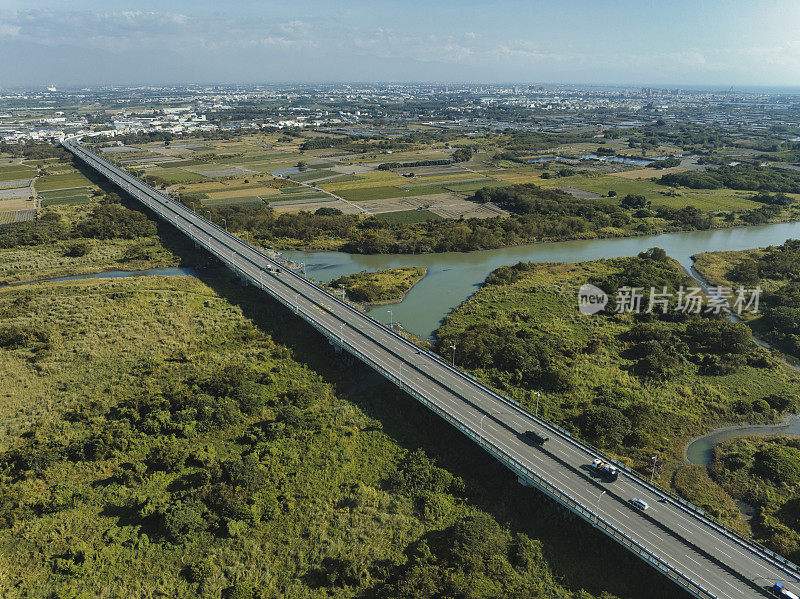 汽车在高速公路路口行驶的鸟瞰图。桥梁道路与绿色花园和树木连接的建筑概念