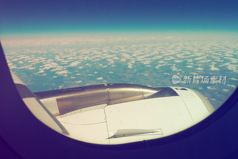 飞机发动机和机翼在大气和空间的边界。对流层的边缘。地球上的地平线。航班、旅行和旅游。从窗户或舷窗看。云和蓝天。