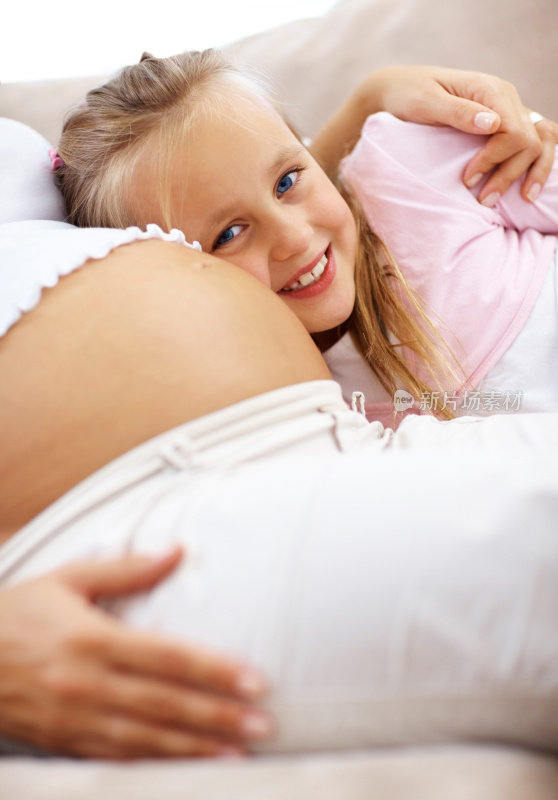 快乐的女儿和她怀孕的母亲坐在一起