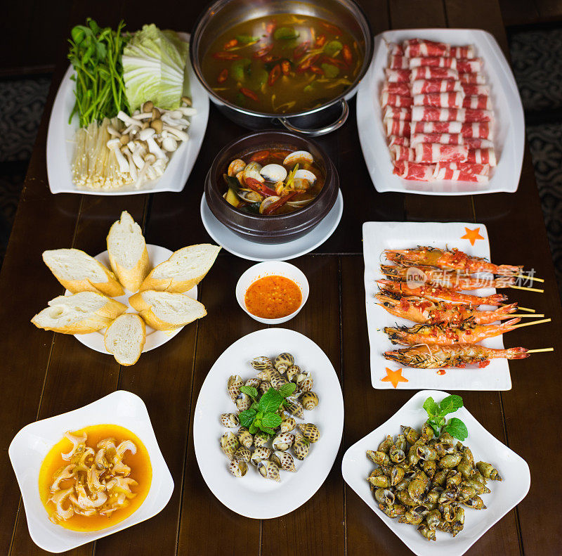 一套越南海鲜配烧烤虎虾，烤甜蜗牛，面包片，辣蒸蛤，蔬菜和生牛肉片火锅