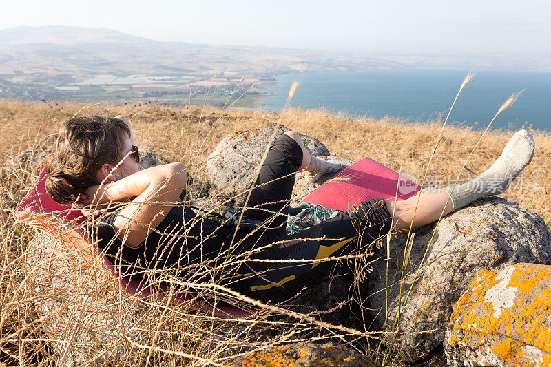 年轻女子躺在高草Kineret湖景。