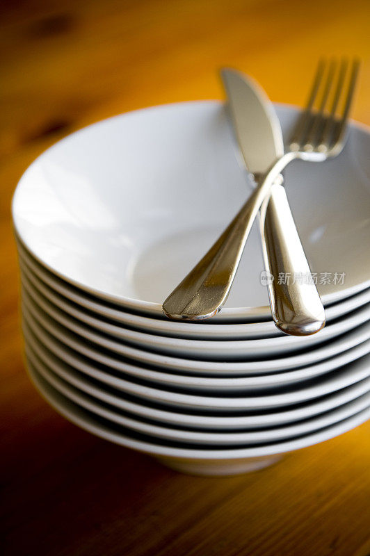 厨房桌子上放着银质餐具的白碗。