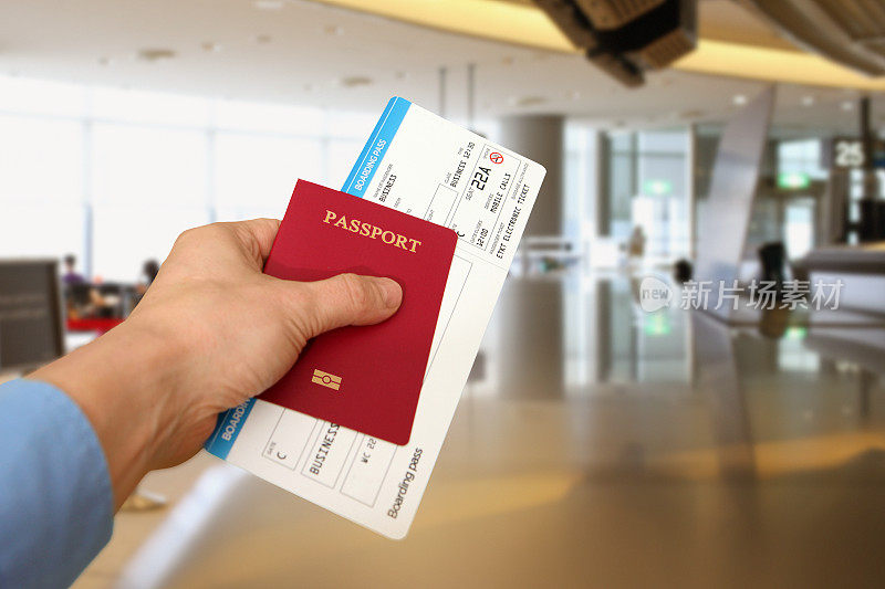 商务旅客在机场办理登机手续，手持护照、登机牌