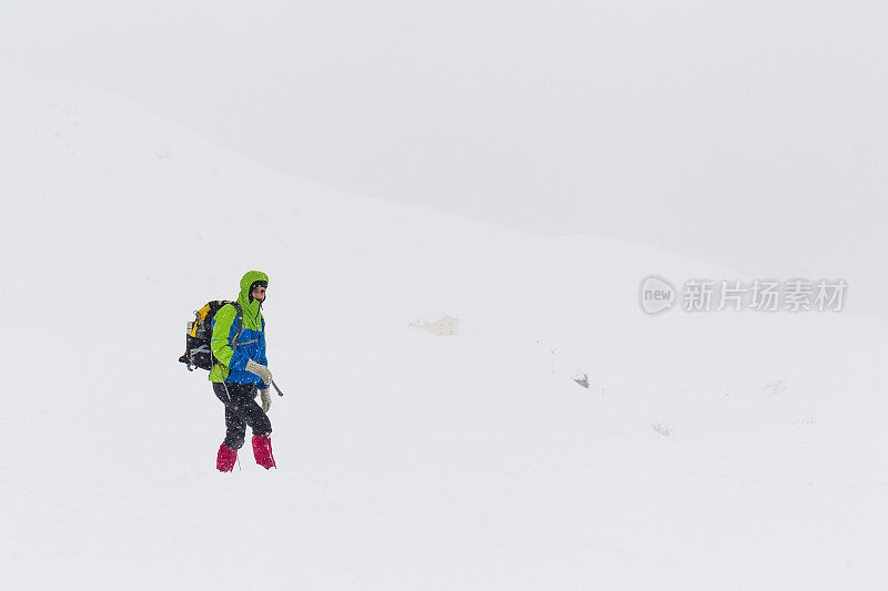 一名登山者在暴风雪中接近山顶