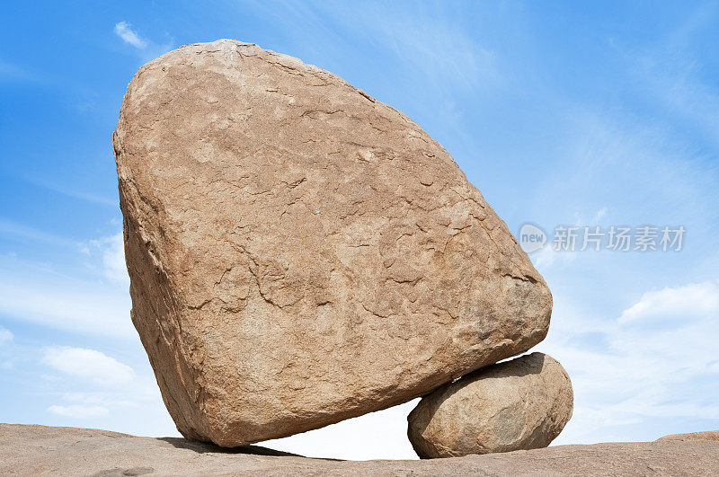 一块大石头摇摇欲坠地在小石头上保持平衡