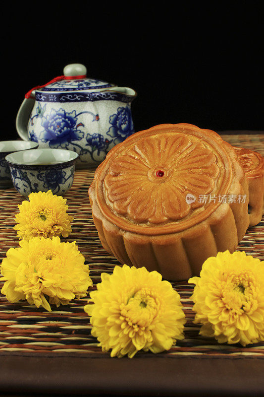 月饼和茶水，垫上装饰着菊花