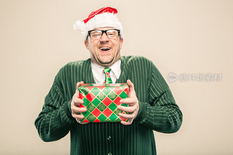 兴高采烈的书呆子圣诞老人拿着包装好的节日礼物