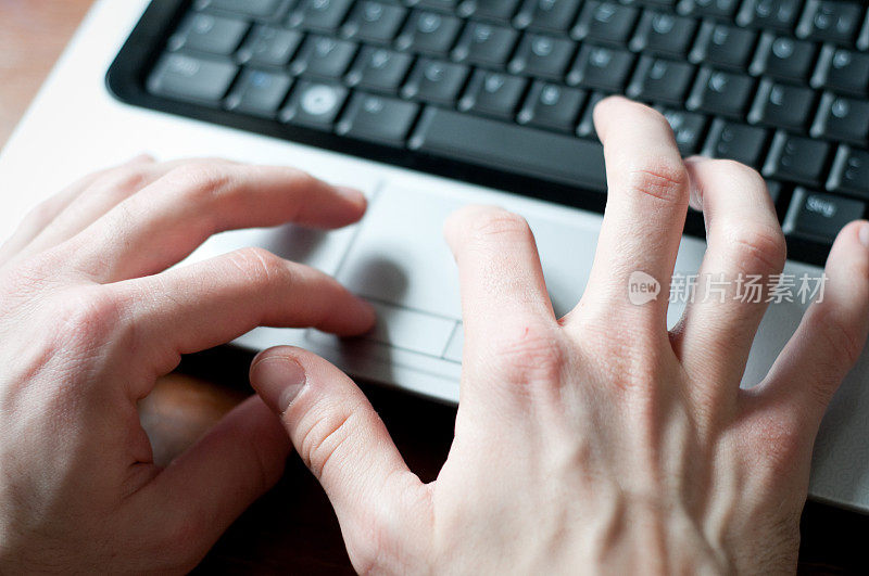 男性双手使用电脑触控板，近景，浅自由度