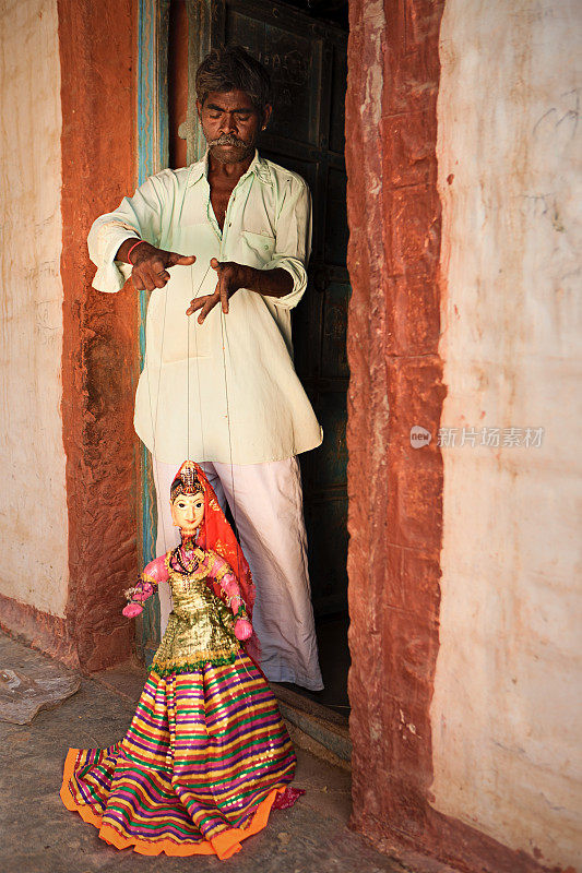 一个印度人在展示如何玩木偶。拉贾斯坦邦