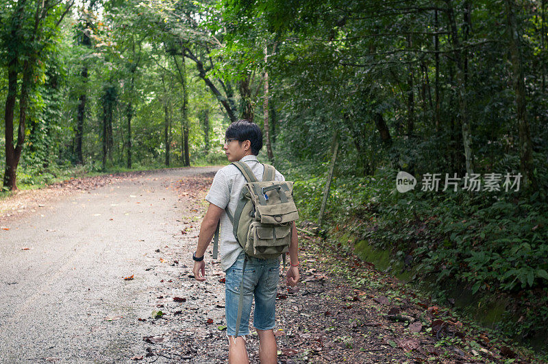 商人背着背包在瀑布森林。