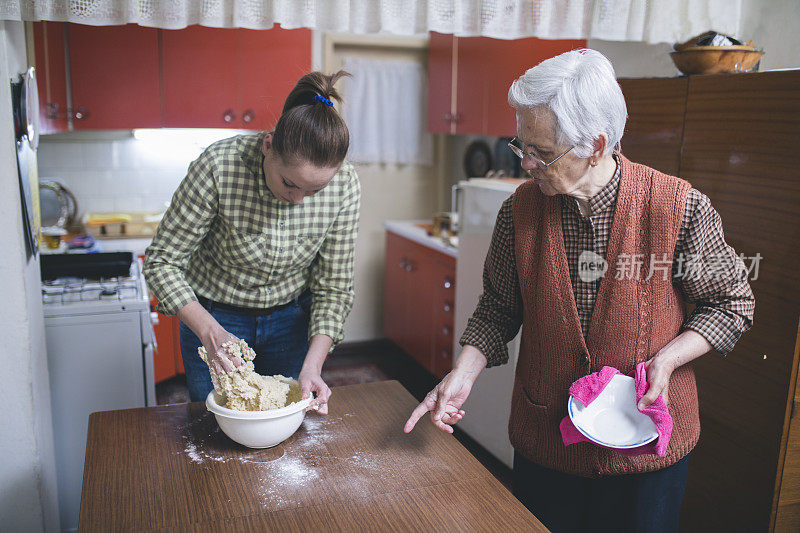 祖母和孙女烘烤饼干准备面团