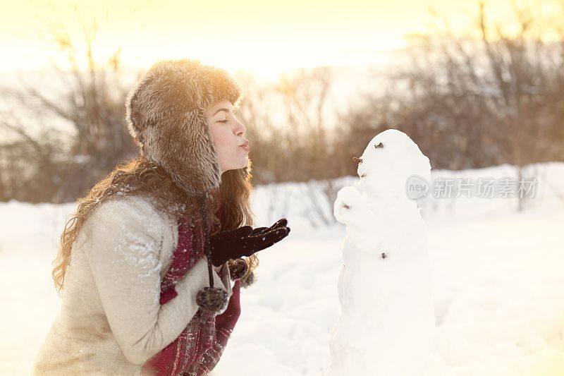 微笑的女人送吻雪人