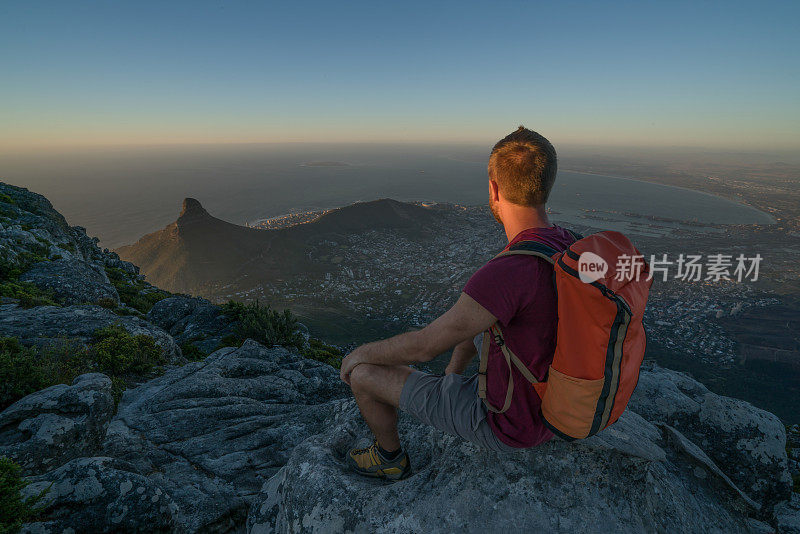 一个年轻人在开普敦山顶上看风景