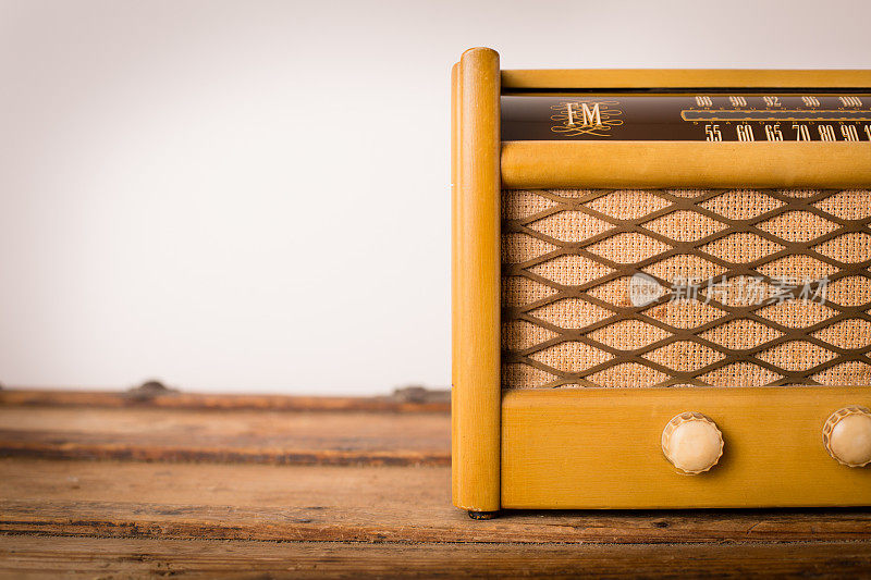 复古黄金收音机坐在木桌上，有拷贝空间