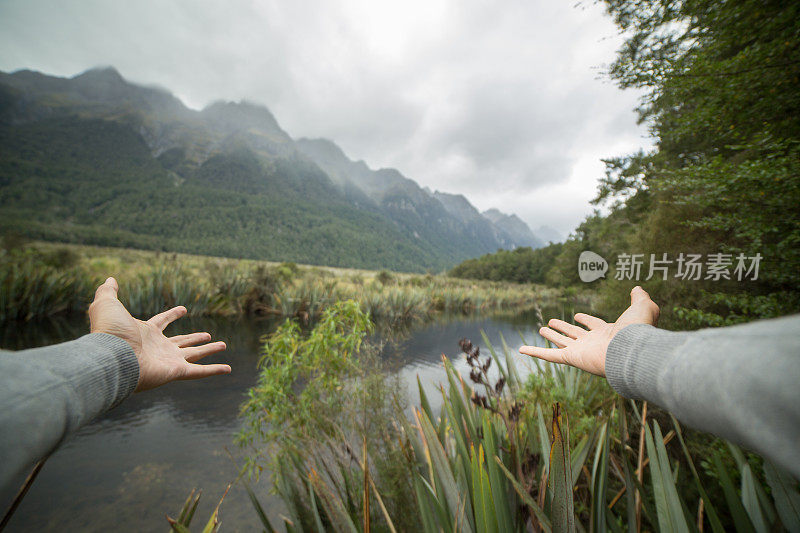 一个人向自然伸出双臂的个人视角