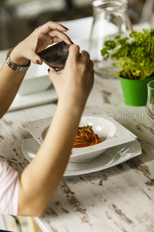 一个女人在拍摄一盘食物