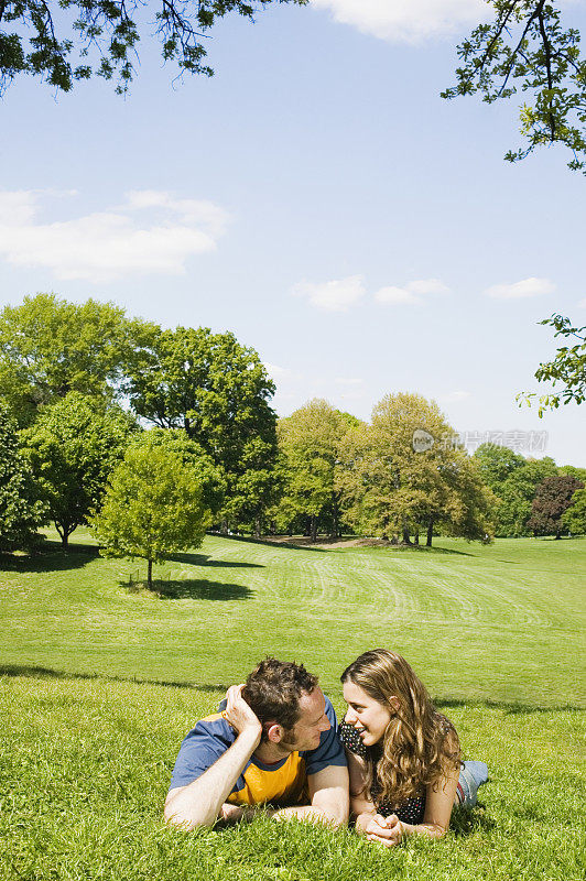 年轻夫妇躺在草地上