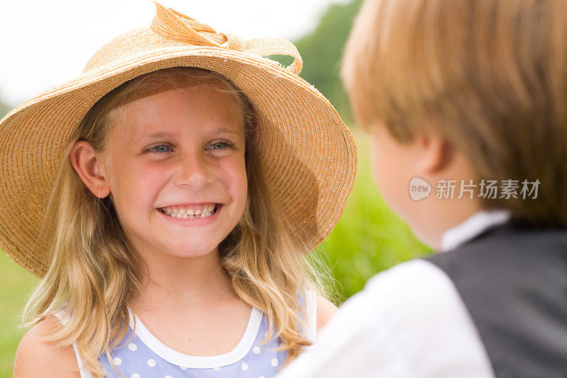 戴草帽的小女孩给小男孩一个微笑