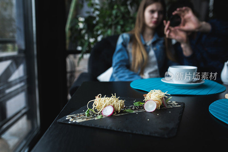 黑盘酱面虎虾。亚洲食品的概念。人们的背景在餐馆的地方与木桌。