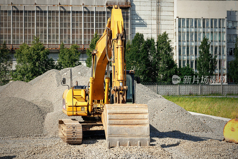 履带式挖掘机在一个建筑工地碎石堆之间