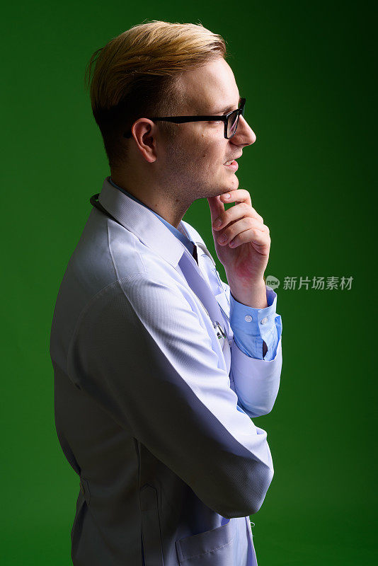 年轻英俊的男医生戴着绿色背景的眼镜