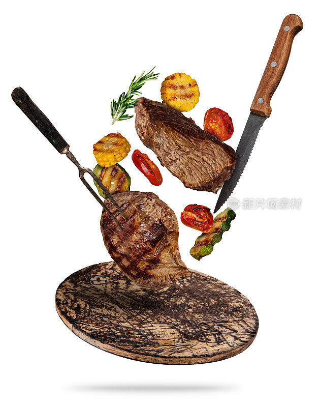 飞牛排配烤蔬菜，放在木砧板上。