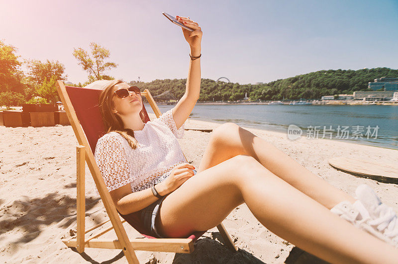 微笑的年轻女孩自拍在海滩度假的场景