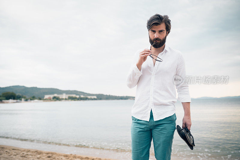 长着胡子的帅哥在海滩上享受一天