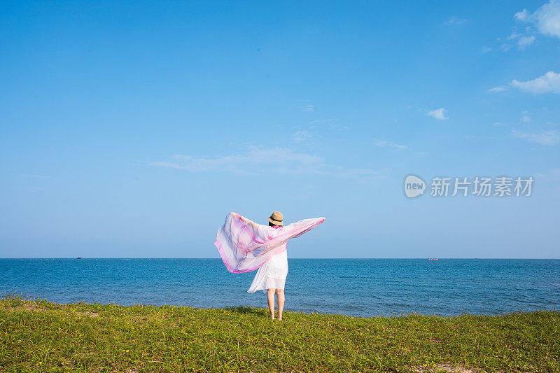 年轻女子站在海岸上