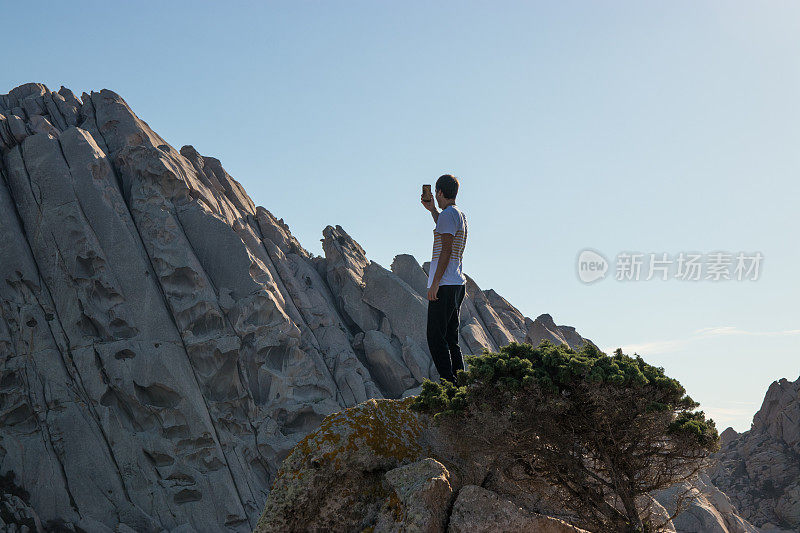 一名男子用智能手机拍摄岩层